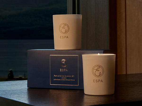 Image of two mini ESPA candles. 70g in a white glass vessel on top of a blue box.