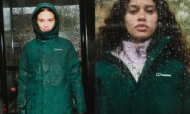 A woman standing in rain in a green berghaus ashberry gore-tex jacket