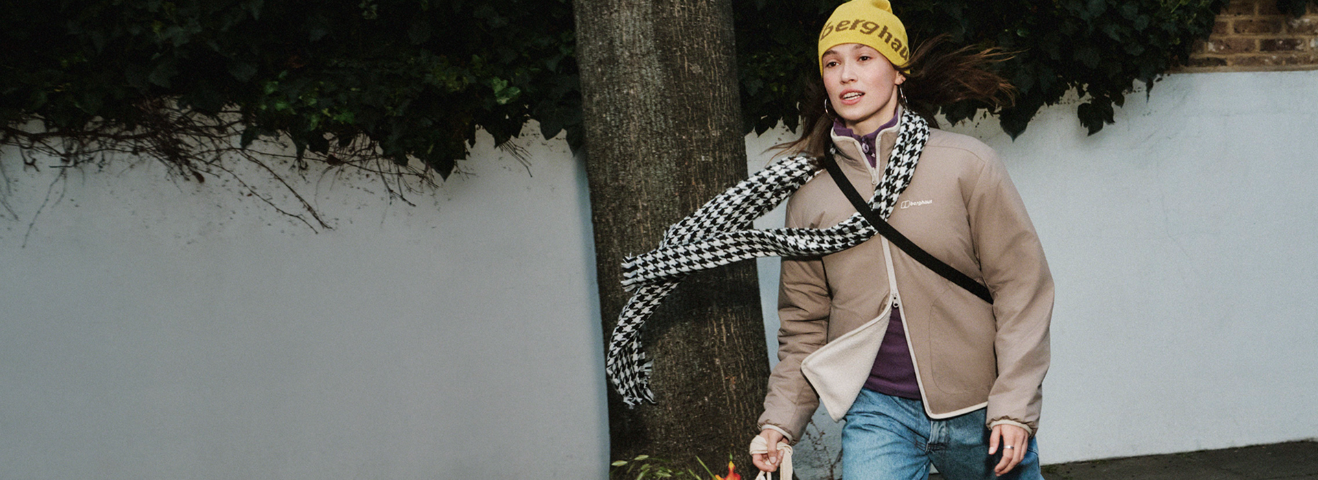 A woman walking in a hat and a fleece in the wind