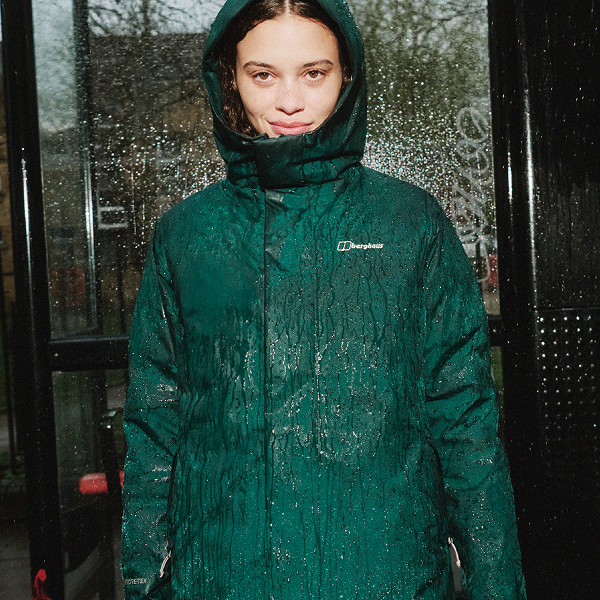 One side of the image is a women wearing a long green Berghaus rain coat. The other side of the image has a picture of a girl behind some rainy glass