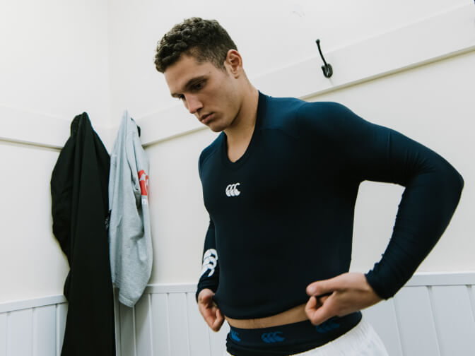 Man putting on a canterbury baselayer