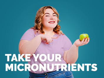 Woman smiling at pointing at apple with text overlay "take your micronutrients"