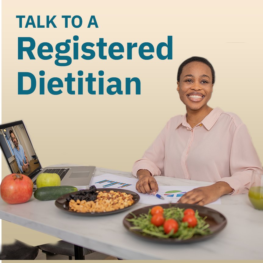 A female doctor sitting at a desk with her laptop, healthy foods and a diet plan in front of her with text overlay "Talk To a Registered Dietitian"