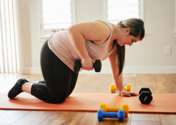 A women on her hands and knees pulling up weights