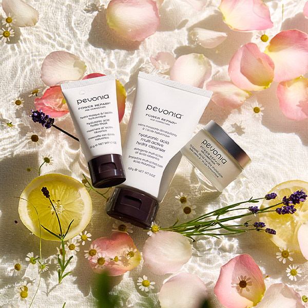 Pevonia's new Hyaluronic Acid cleanser lay in a bed of water, accompanied by the natural ingredients of the product including lemon, rose petals and Lavendar. 