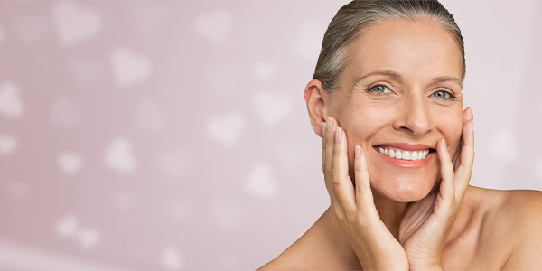 Womeh with her hand out and Product spotted on her face to show Pevonia Skin Care Products and promote the Refer a Friend Scheme